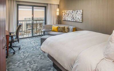 Double bed guest room in Sonesta Select Seattle Bellevue Redmond, furnished with chair, desk, and sofa.