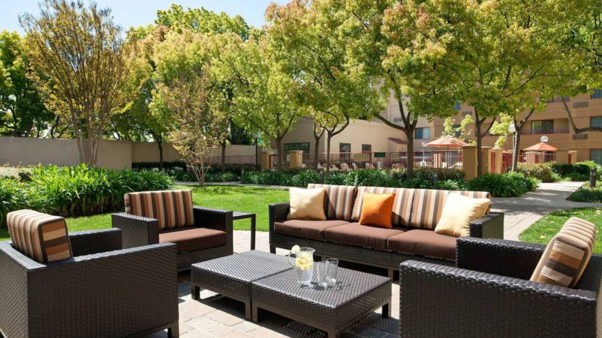The hotel’s patio has trees nearby, and a mix of sofa and armchair seating.
