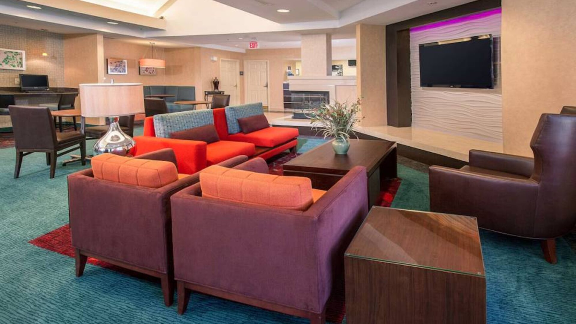 The hotel’s lobby lounge features comfortable chairs facing a widescreen, wall-mounted TV, with coffee tables close at hand.