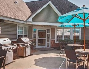 The hotel’s patio area includes shaded tables and chairs, as well as multiple barbecues.