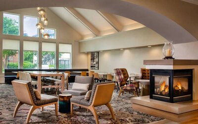The hotel’s lobby lounge has large windows, extensive seating, coffee tables, and a fireplace.