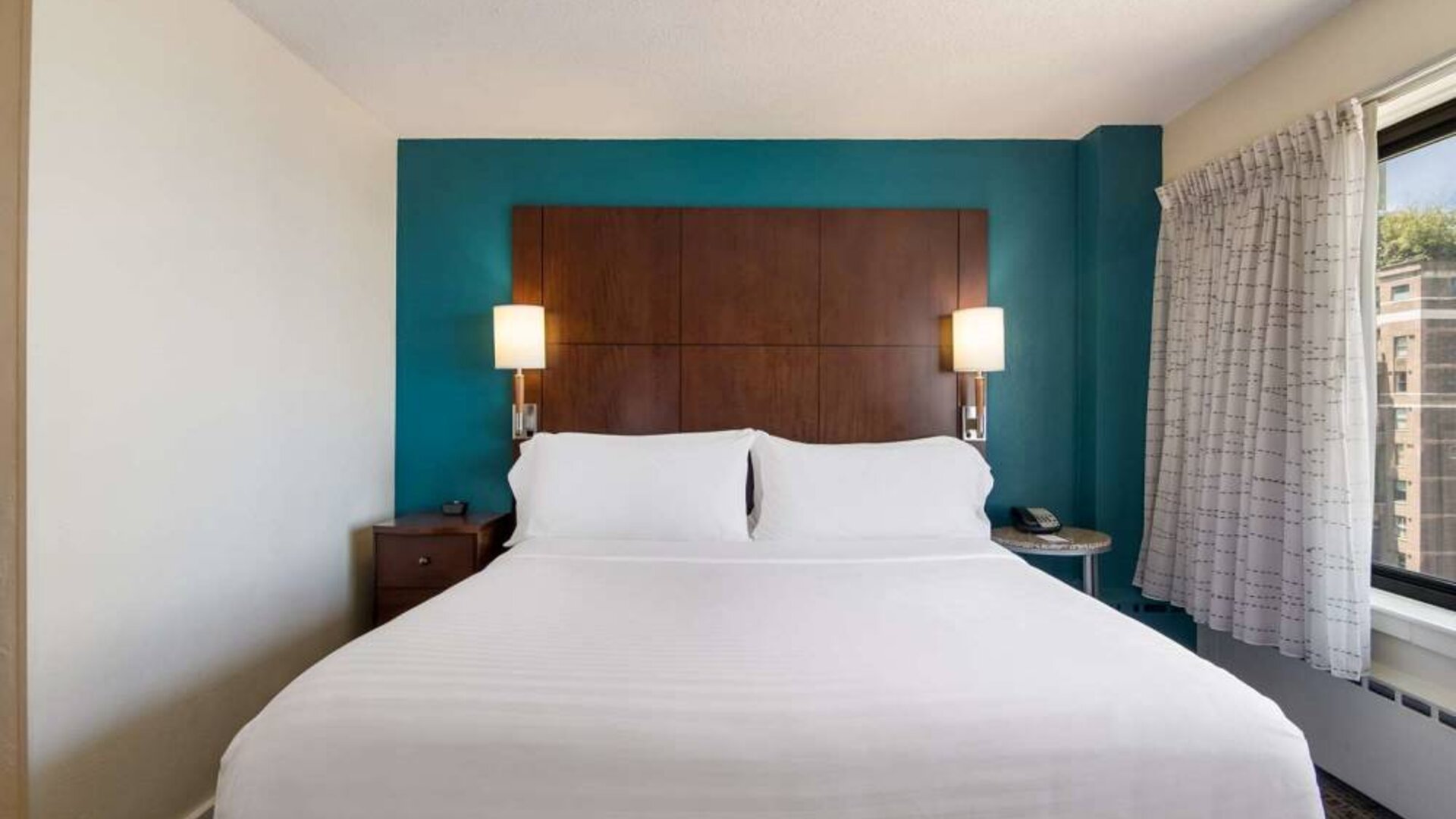 Double bed guest room in Sonesta ES Suites Chicago Downtown Magnificent Mile - Medical, with bedside lamps and window.
