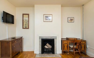 Day use room with TV, workspace, and chimney at The Farrington Inn.