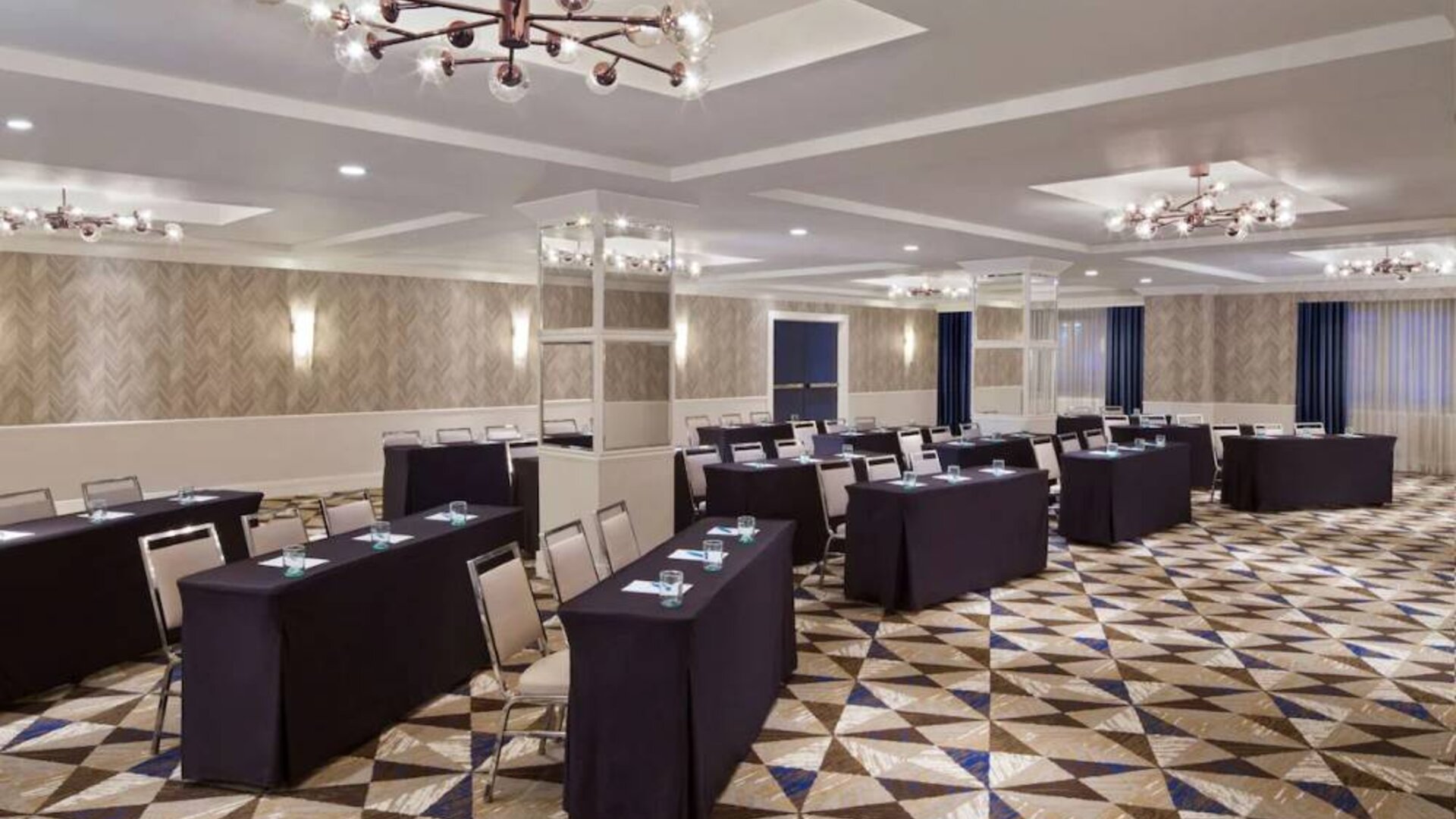 Large meeting room in Royal Sonesta Washington DC Dupont Circle, with tables of three seats each arranged in a classroom style.