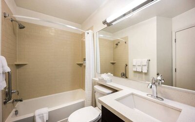 Sonesta Simply Suites Arlington guest bathroom, including bath with a shower, sink, and lavatory.