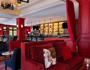 The Stephen F Austin Royal Sonesta Hotel’s bar has vibrant red decor, and a mix of comfortable table seating and traditional bar stools.