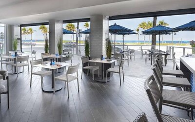 Sonesta Fort Lauderdale Beach’s Steelpan Restaurant serves up Caribbean-American fusion fare, with small tables, a hard floor and ocean views.