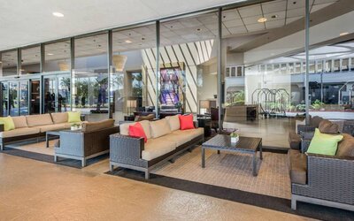 Sonesta Los Angeles Airport LAX’s lobby lounge features comfy sofa and armchair seating, and large coffee tables.