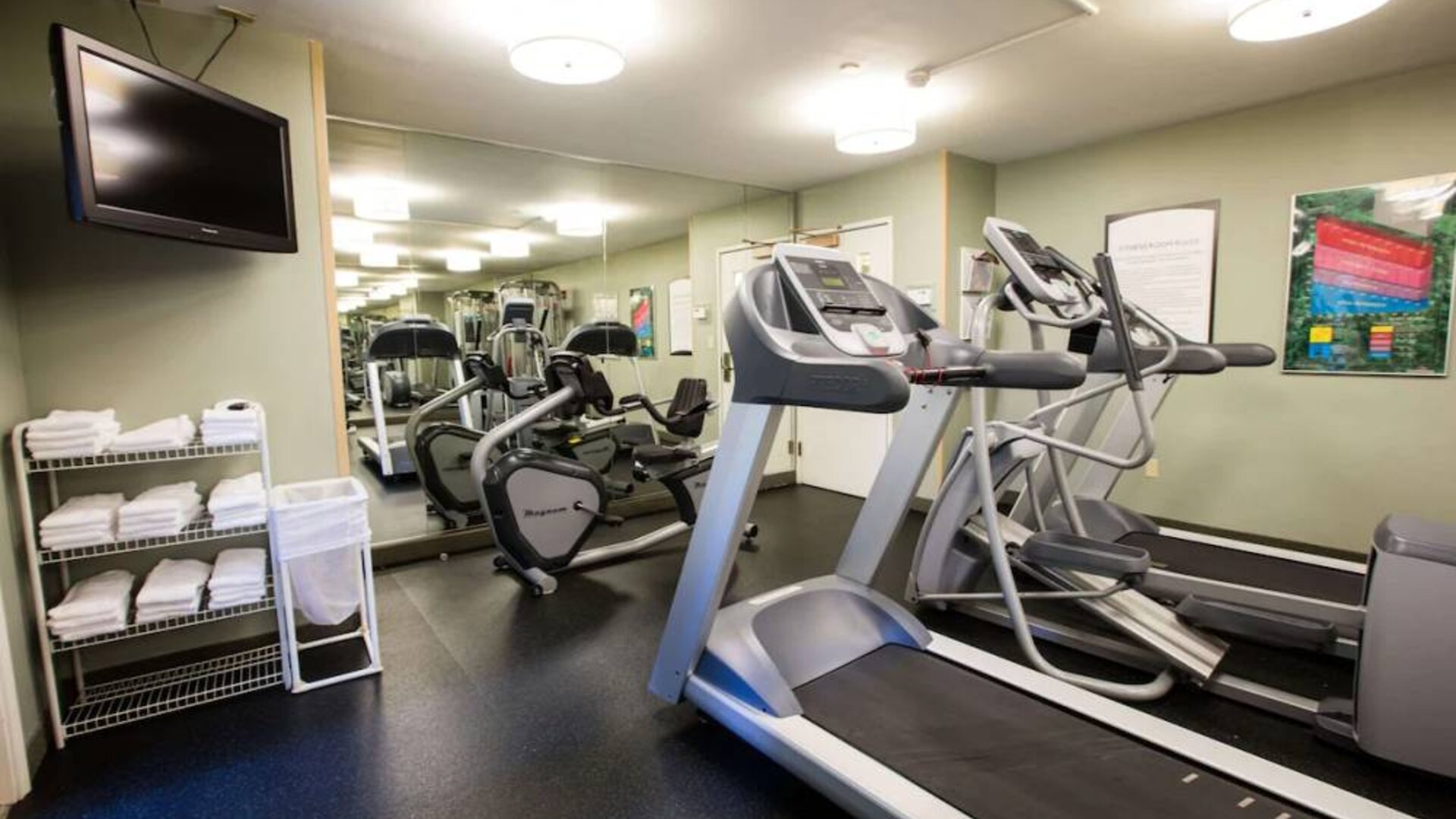 The fitness center at Sonesta ES Suites Austin The Domain Area includes a widescreen television, plenty of towels, and multiple exercise machines.