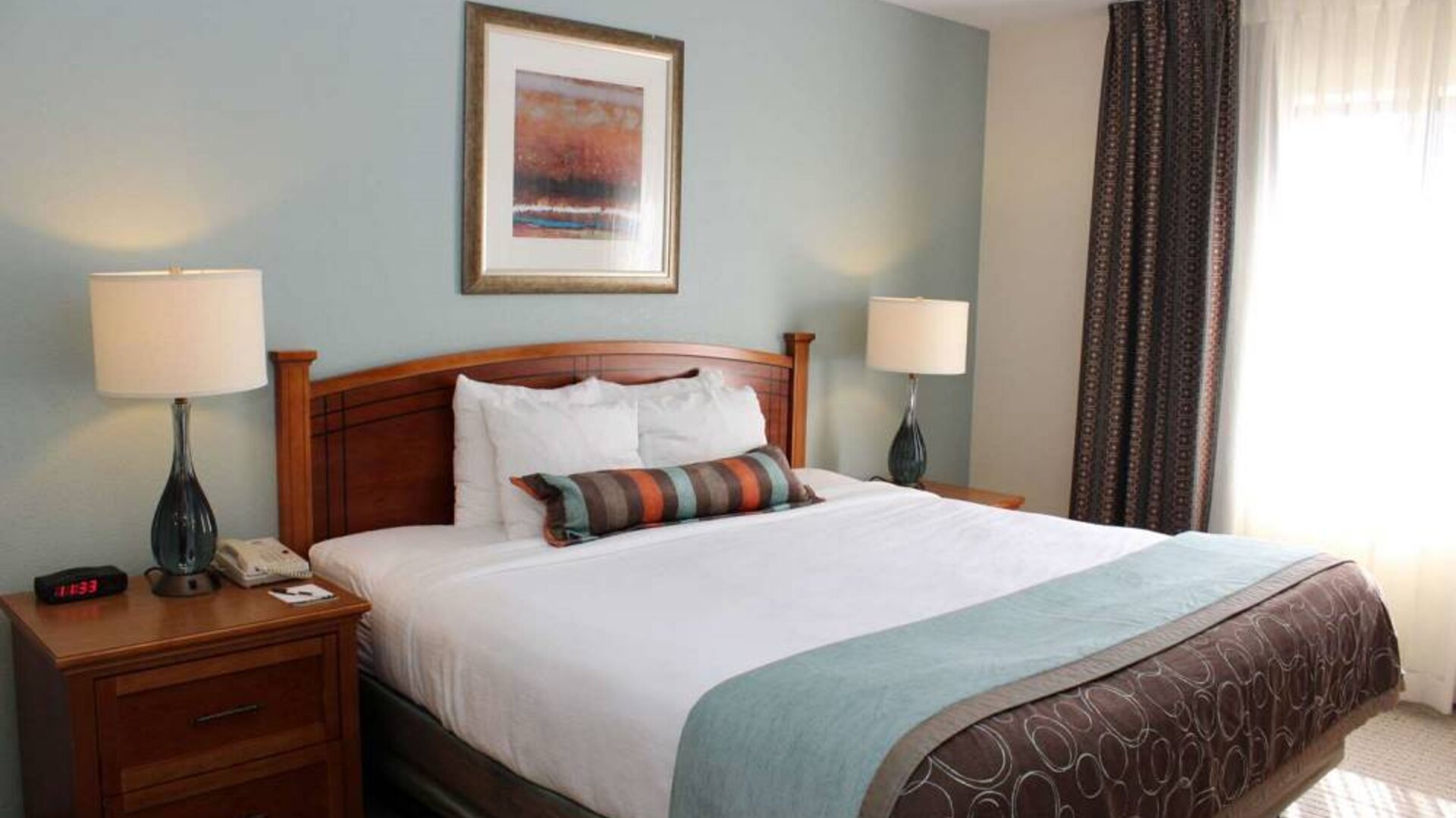 Sonesta ES Suites Portland Vancouver 41st Street double bed guest room, featuring art on the wall and a large window.