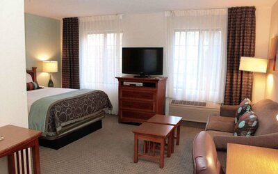 Double bed guest room in Sonesta ES Suites Portland Vancouver 41st Street, including lounge area with sofa, TV, and coffee tables.