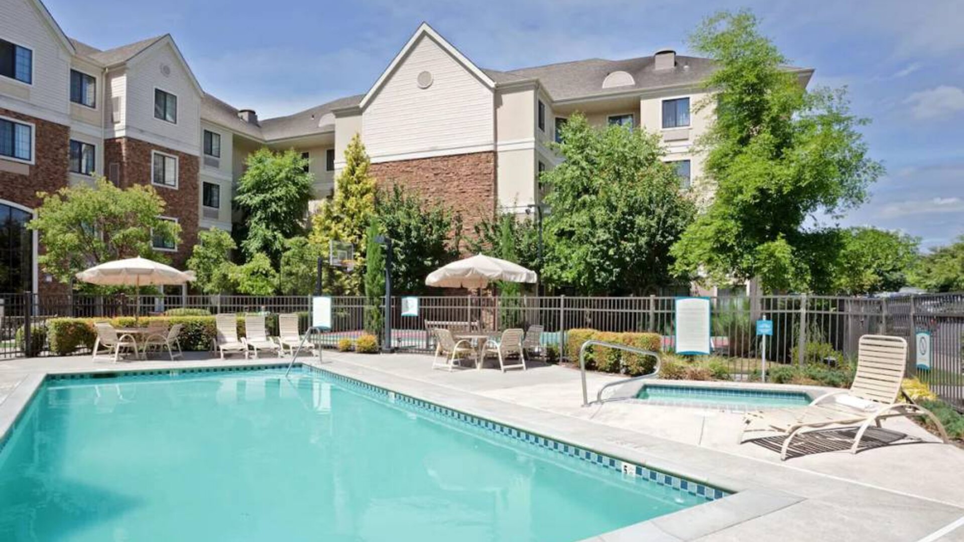 Sonesta ES Suites Portland Vancouver 41st Street’s outdoor pool has a nearby hot tub, with sun loungers, and shaded tables and chairs in the vicinity.