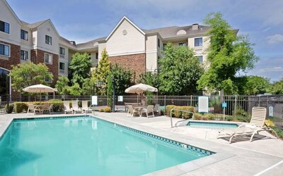Sonesta ES Suites Portland Vancouver 41st Street’s outdoor pool has a nearby hot tub, with sun loungers, and shaded tables and chairs in the vicinity.