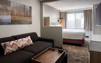 Sonesta Select Seattle Renton double bed guest room, featuring TV, window, and sofa.