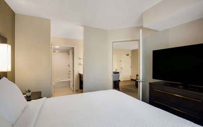 Double bed guest room in Sonesta ES Suites Parsippany Morris Plains, featuring ensuite bathroom and large television.