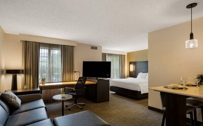 Sonesta ES Suites Parsippany Morris Plains double bed guest room, including TV and sofa, with a workspace desk and chair.