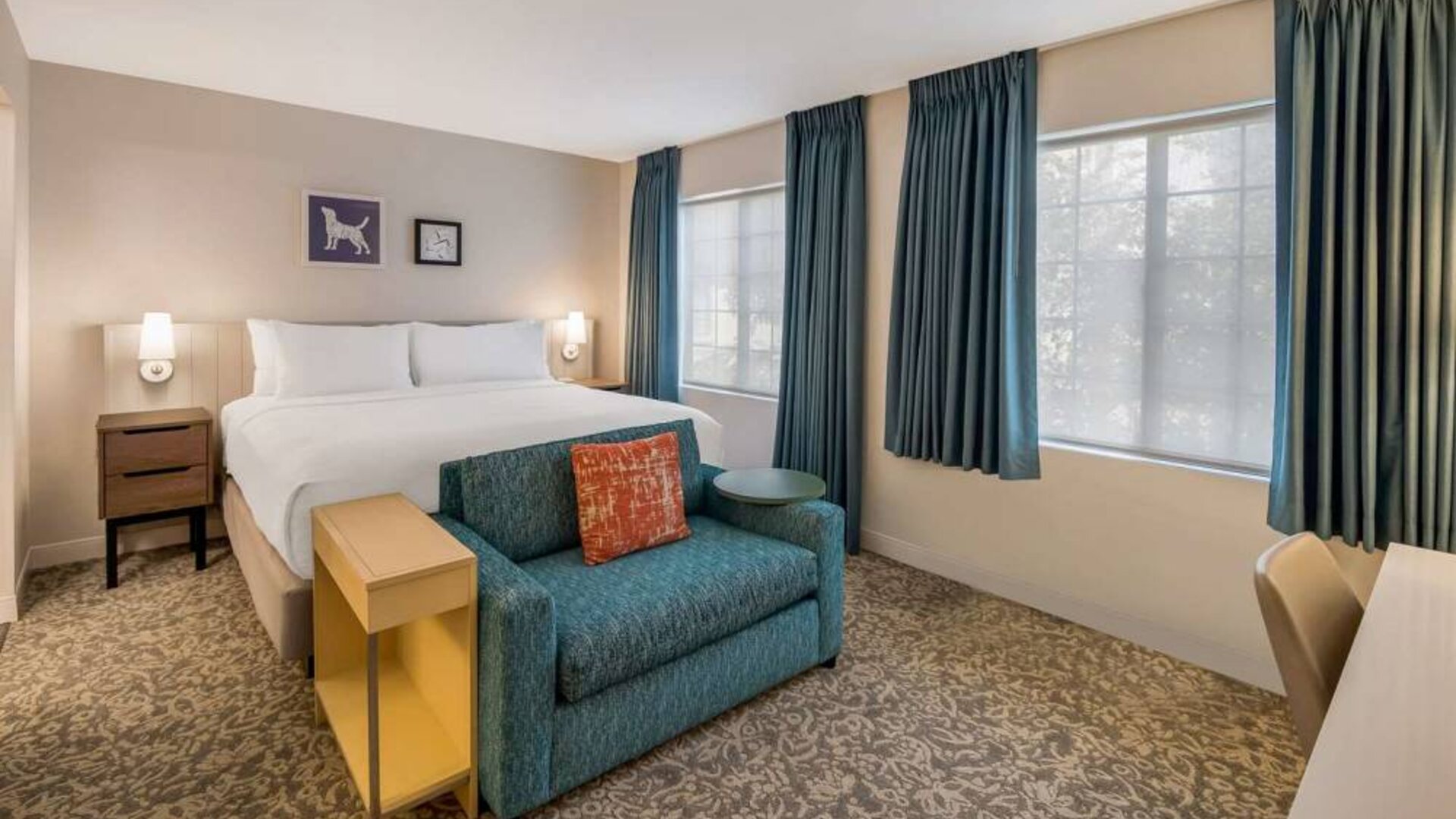 Sonesta ES Suites Andover Boston double bed guest room, including sofa, coffee table, and two windows.