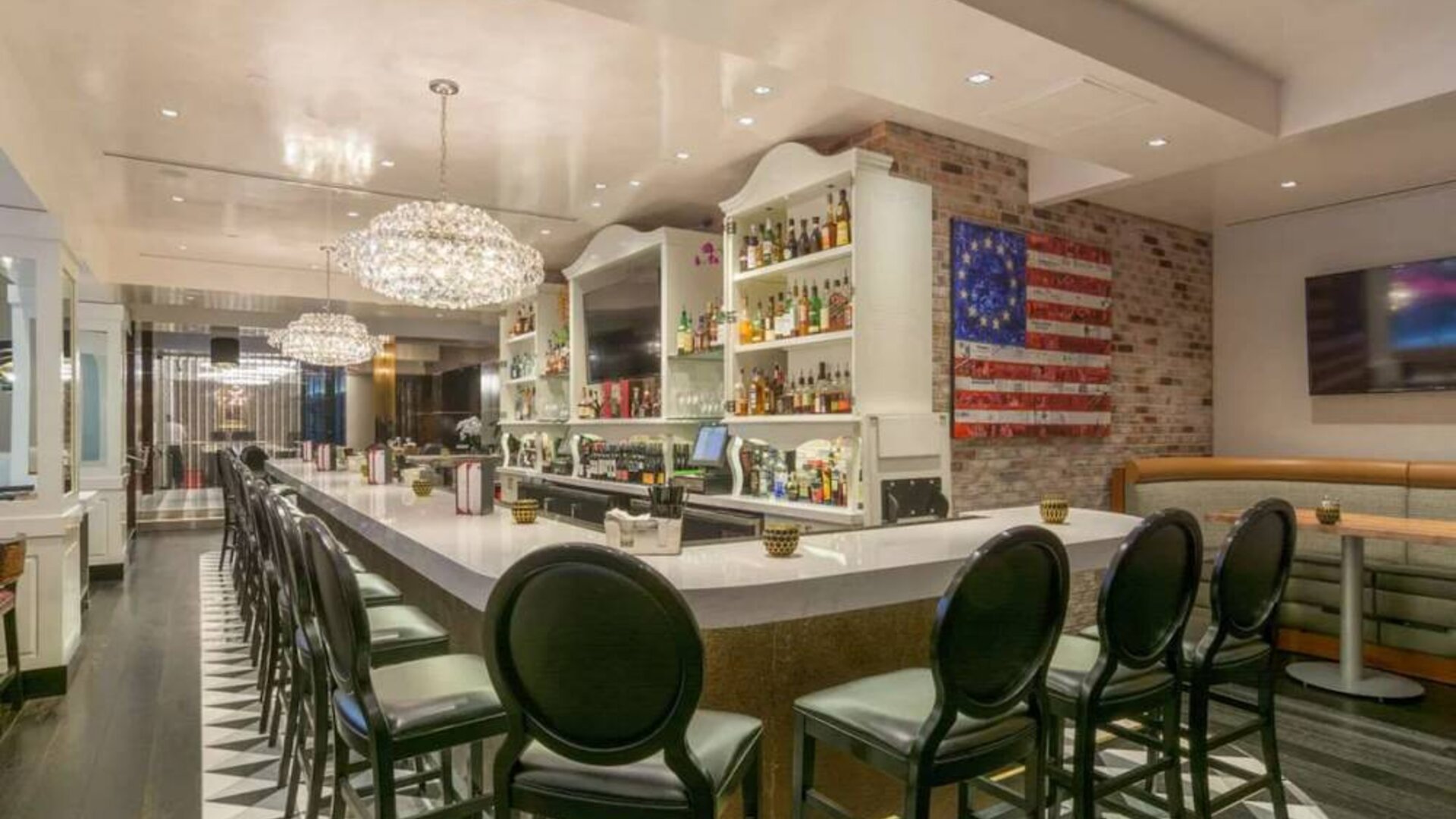 The hotel restaurant has tall stool seating at the bar, an extensive range of beverages, and an artistic 13 star Betsy Ross variant of the Stars and Stripes on the wall.