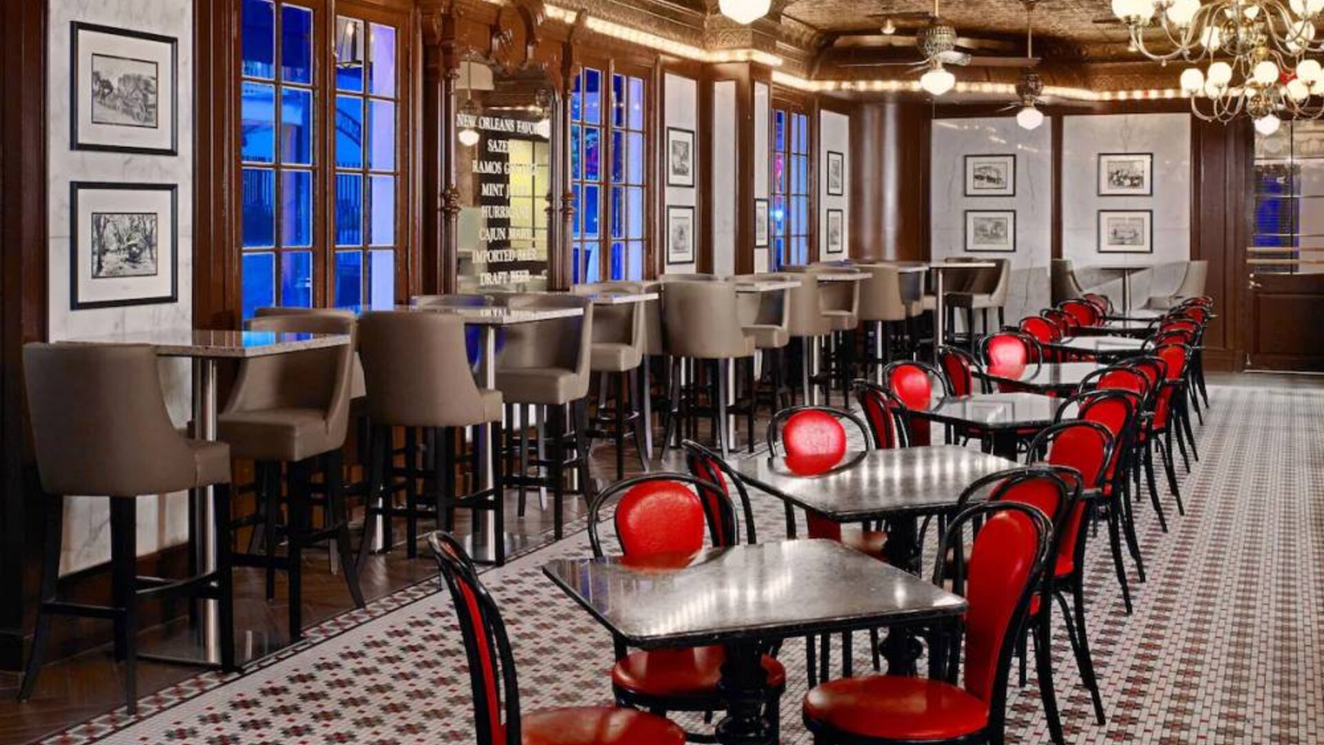 Guests can dine at the hotel restaurant, which has a mosaic-style floor, small tables, and a mix of regular and tall stool seating.