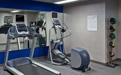 The hotel fitness center is equipped with towels, gym balls, and exercise machines such as an elliptical and a treadmill.