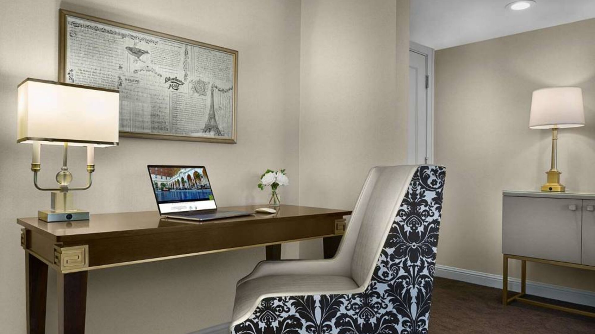 The Chase Park Plaza Royal Sonesta St. Louis guest room workspace, furnished with desk, chair, and lamp.