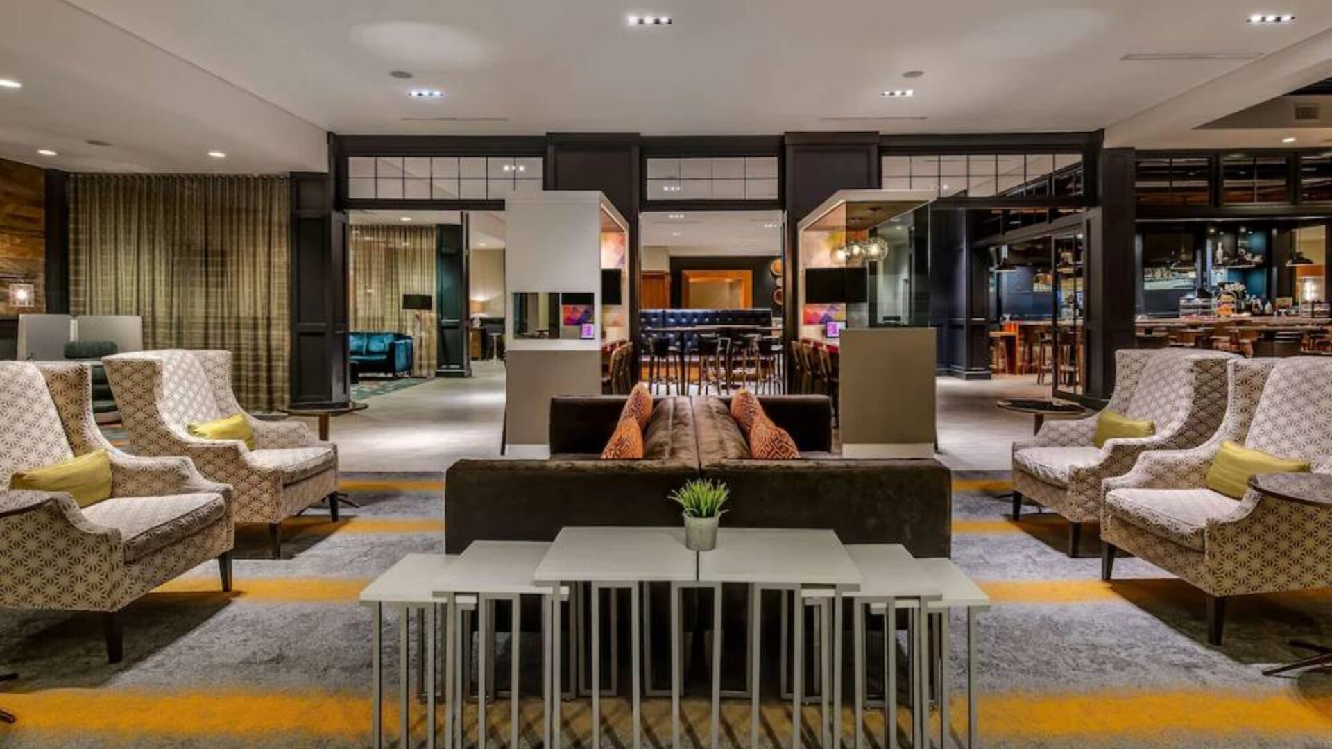 Sonesta Charlotte Executive Park’s lobby lounge is furnished with comfortable armchair and sofa seating for guests to relax and socialize.