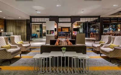 Sonesta Charlotte Executive Park’s lobby lounge is furnished with comfortable armchair and sofa seating for guests to relax and socialize.