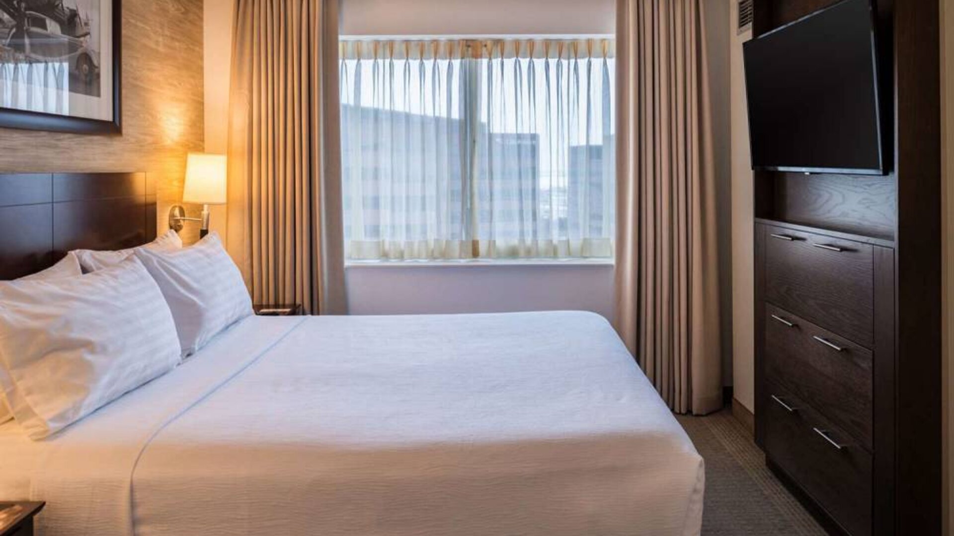 Sonesta Chicago O'Hare Airport Rosemont double bed guest room with window and wall-mounted TV.