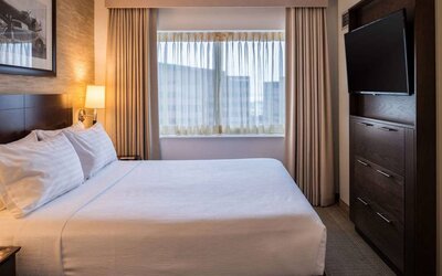 Sonesta Chicago O'Hare Airport Rosemont double bed guest room with window and wall-mounted TV.