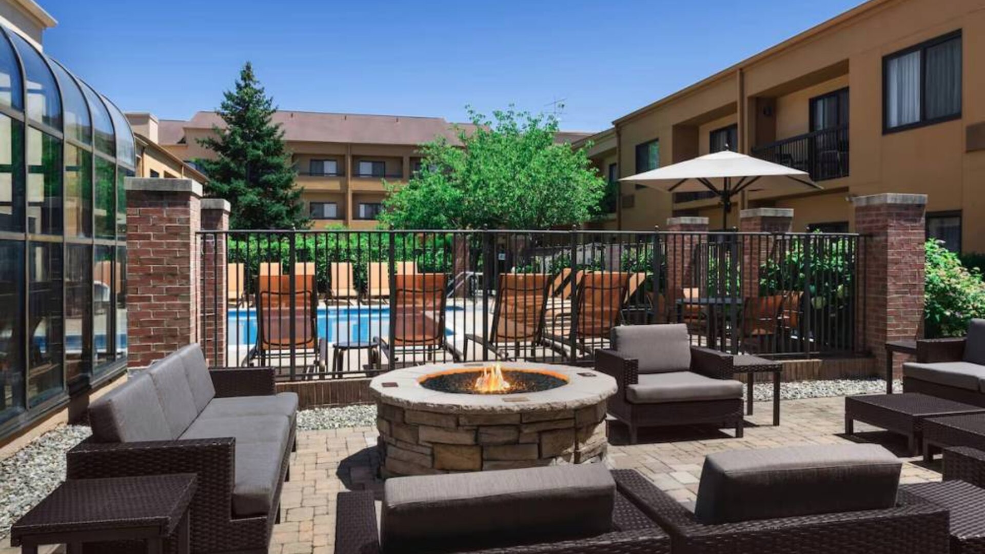 Sonesta Select Newport Middletown’s fire pit has comfortable armchair and sofa seating nearby, and is close to the pool.