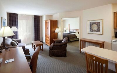 Double bed guest room in Sonesta ES Suites San Antonio Northwest - Medical Center, featuring sofa and armchair, plus workspace desk and chair.