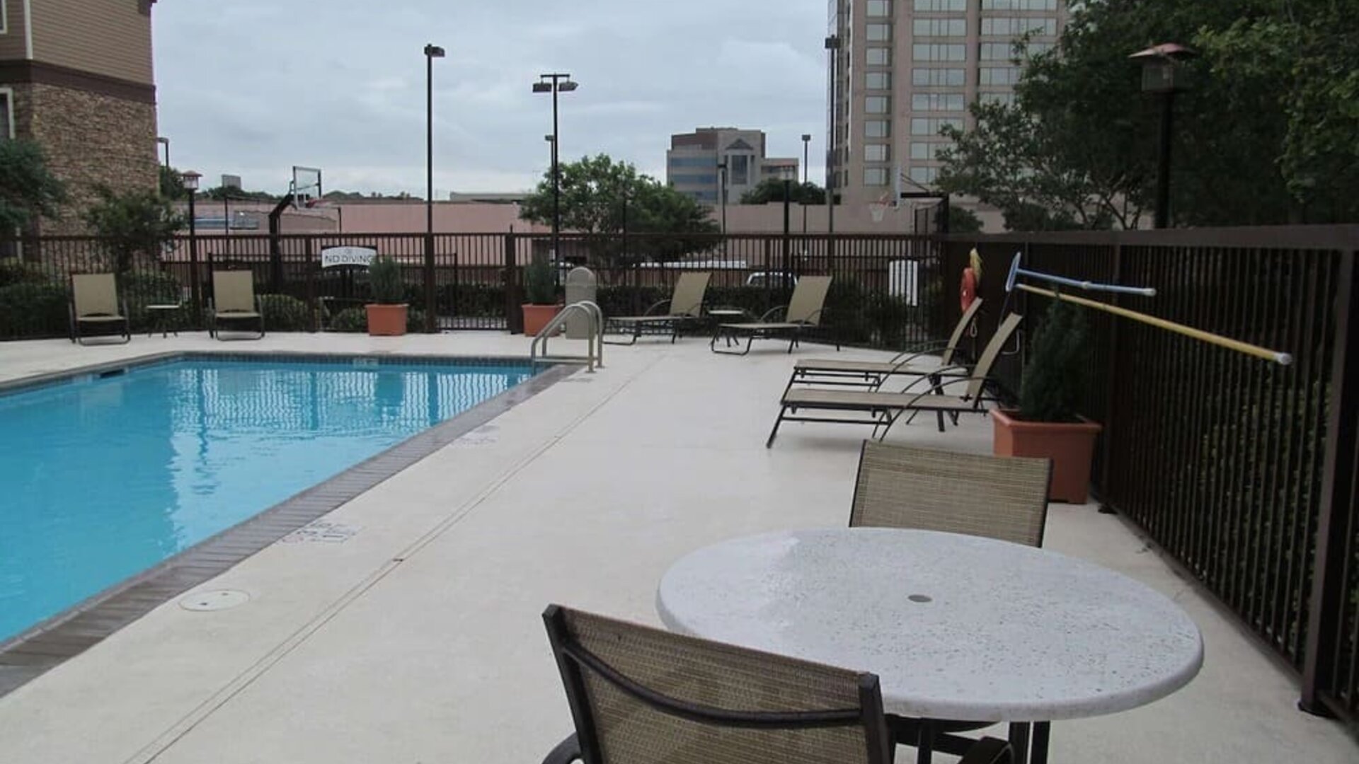 Sonesta ES Suites San Antonio Northwest - Medical Center’s outdoor pool is ringed by a fence, and has nearby tables and chairs, as well as sun loungers.