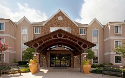 Sonesta ES Suites San Antonio Northwest - Medical Center’s exterior has pleasant greenery and benches, and a covered entranceway.