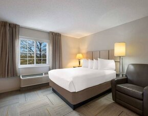 Double bed guest room in Sonesta Simply Suites Huntsville Research Park, including a window and armchair.