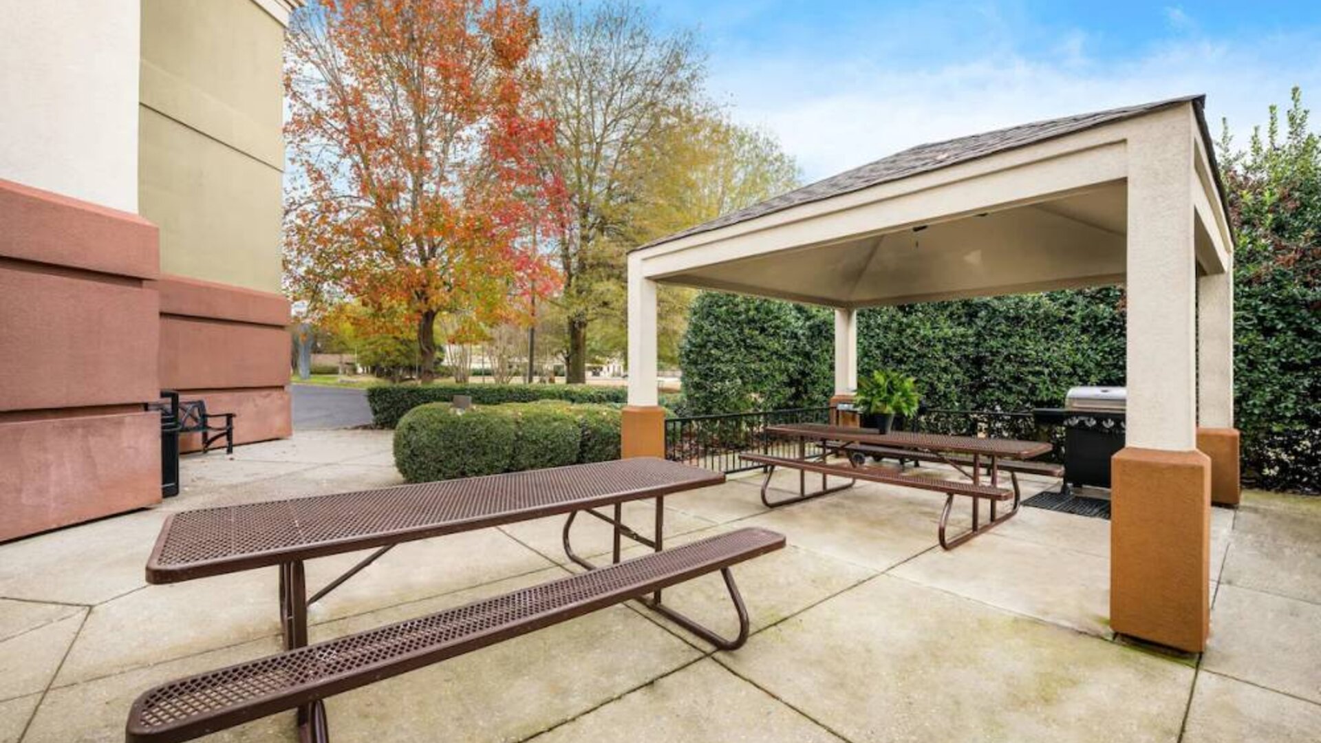 Sonesta Simply Suites Huntsville Research Park’s barbecue facilities has two nearby picnic tables, one within the gazebo and one outside it.