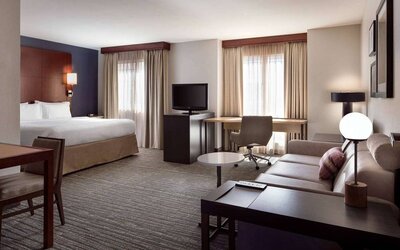 Sonesta ES Suites Fort Lauderdale Plantation double bed guest room, with sofa, TV, and windows, plus a workspace desk and chair.