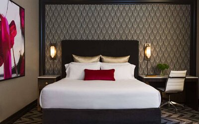 The Allegro Royal Sonesta Hotel Chicago Loop double bed guest room, with art on the wall and a workspace desk and chair.