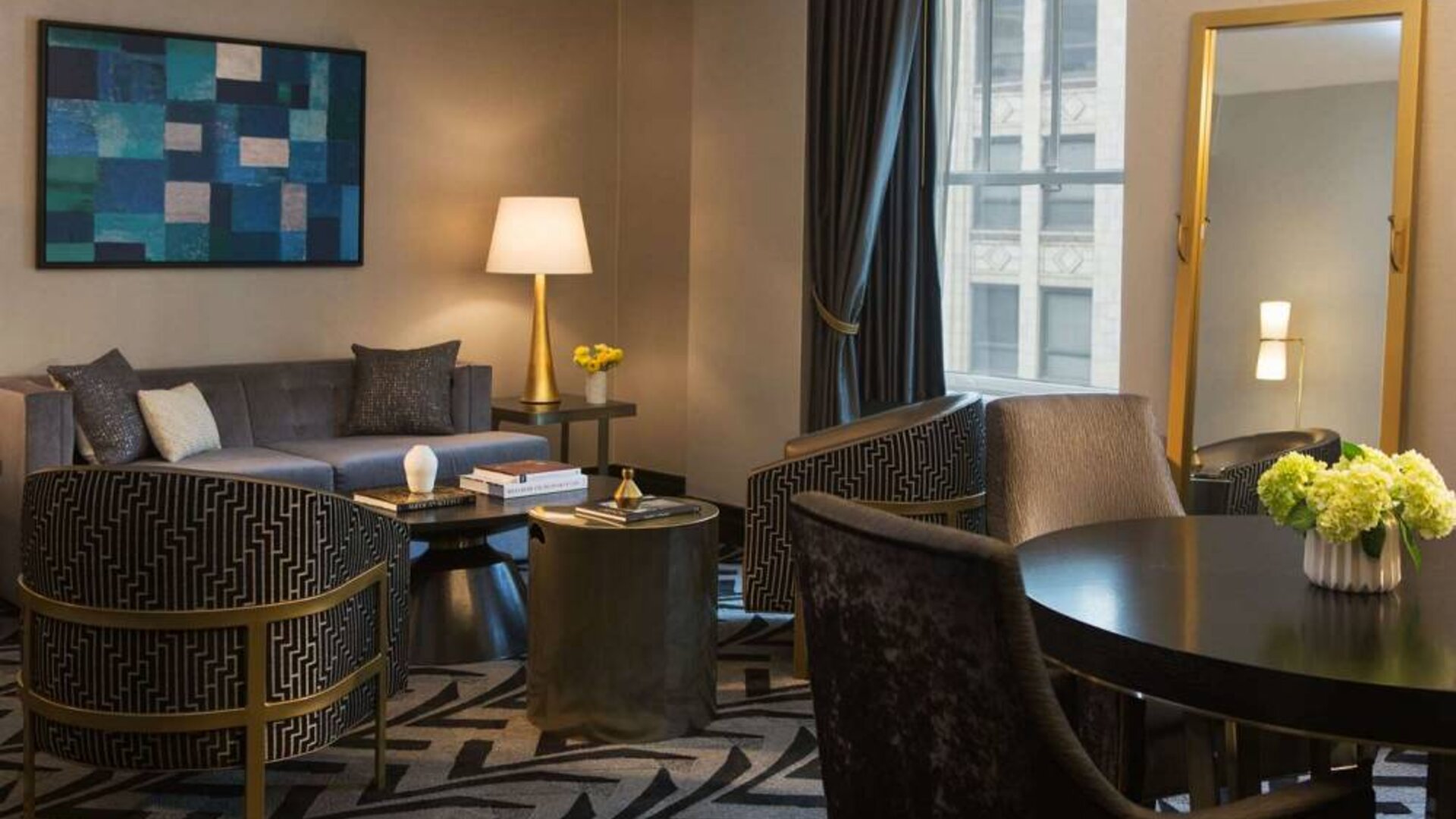 Lounge within a guest room of The Allegro Royal Sonesta Hotel Chicago Loop, including sofa, armchairs, coffee tables, and a window.