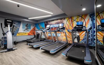 The fitness center in The Allegro Royal Sonesta Hotel Chicago Loop has assorted types of exercise machine and motivational artwork on the wall.