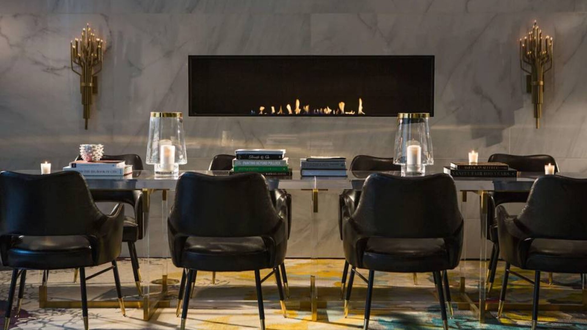 The Allegro Royal Sonesta Hotel Chicago Loop’s lobby lounge includes a table, comfortable seating, and a fireplace.