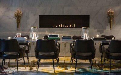 The Allegro Royal Sonesta Hotel Chicago Loop’s lobby lounge includes a table, comfortable seating, and a fireplace.