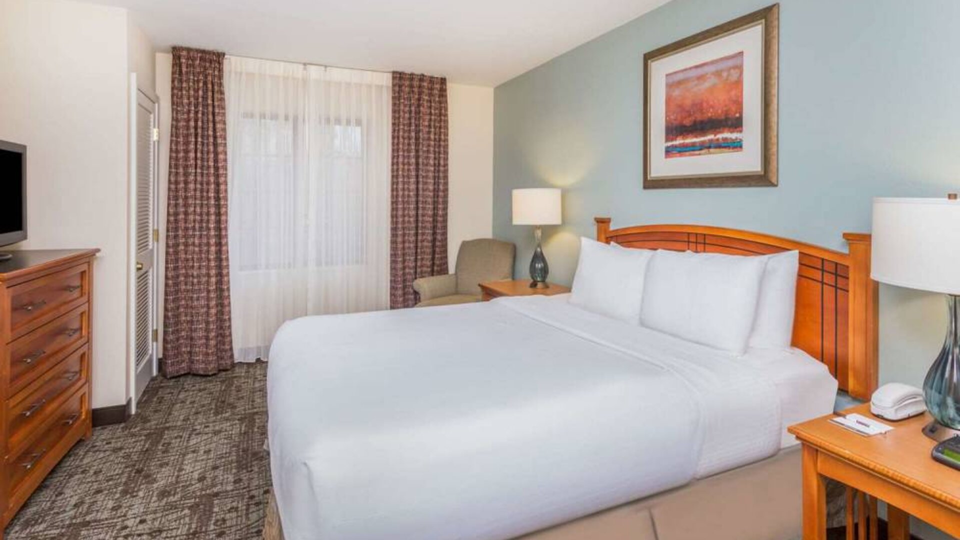 Sonesta ES Suites Atlanta - Perimeter Center double bed guest room, featuring TV, armchair, and window.