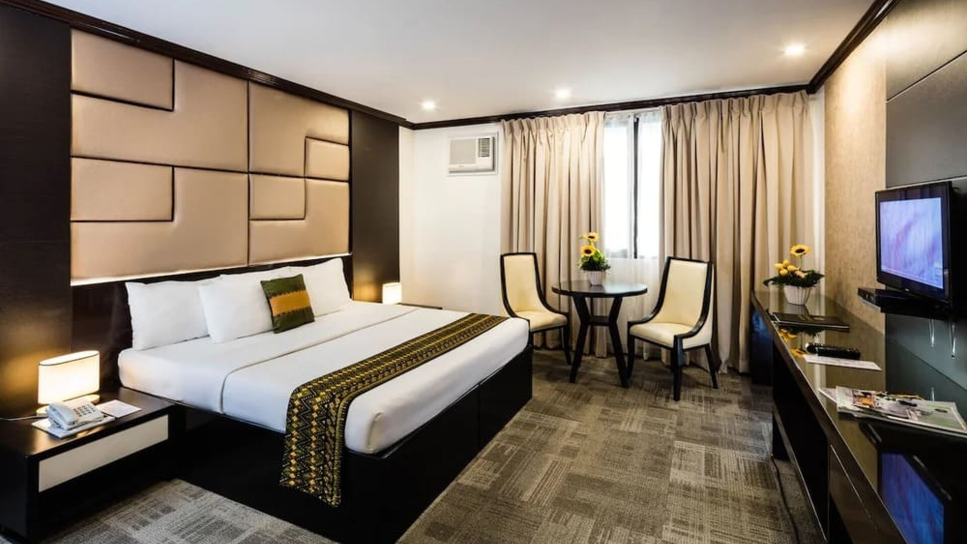 King room with chairs and work space at Apo View Hotel.