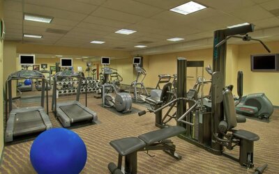 Royal Sonesta Portland Downtown’s fitness center is equipped with free weights, a wall-mounted TV, and assorted exercise machines.