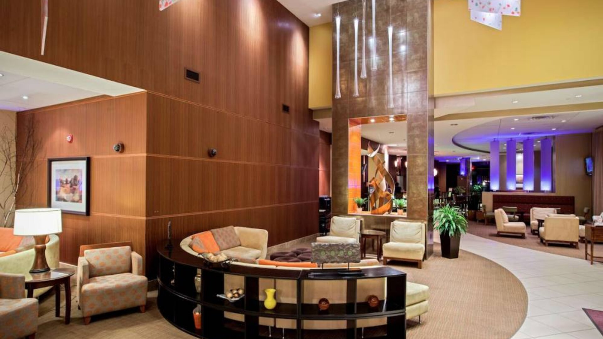 Sonesta Milwaukee West Wauwatosa’s lobby lounge features comfy armchair and sofa seating, a high ceiling, and coffee tables.