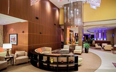 Sonesta Milwaukee West Wauwatosa’s lobby lounge features comfy armchair and sofa seating, a high ceiling, and coffee tables.