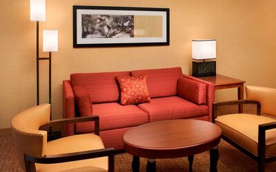 Sonesta Select Detroit Auburn Hills guest room living area, including two chairs, coffee tables, and a sofa.