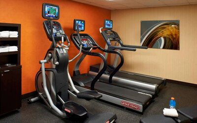 The hotel fitness center has art on the wall and a range of exercise equipment, including treadmills and an elliptical.