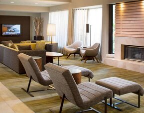 Sonesta Select Boca Raton’s lobby lounge has sofas, chairs, and reclined seats, plus coffee tables, a fireplace, and a wall-mounted television.