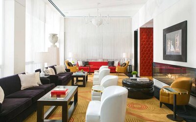 The lounge in Royal Sonesta Chicago River North has comfy chairs and numerous sofas, coffee tables, and large windows creating plenty of natural light.